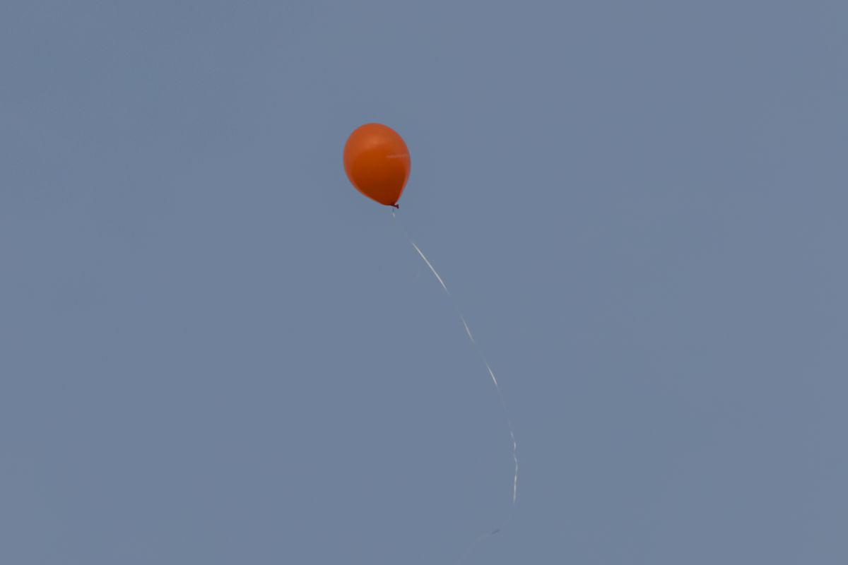 Orange balloon drifting away with its string hanging loose, representing a coroutine detached from viewModelScope by launch(SupervisorJob())
