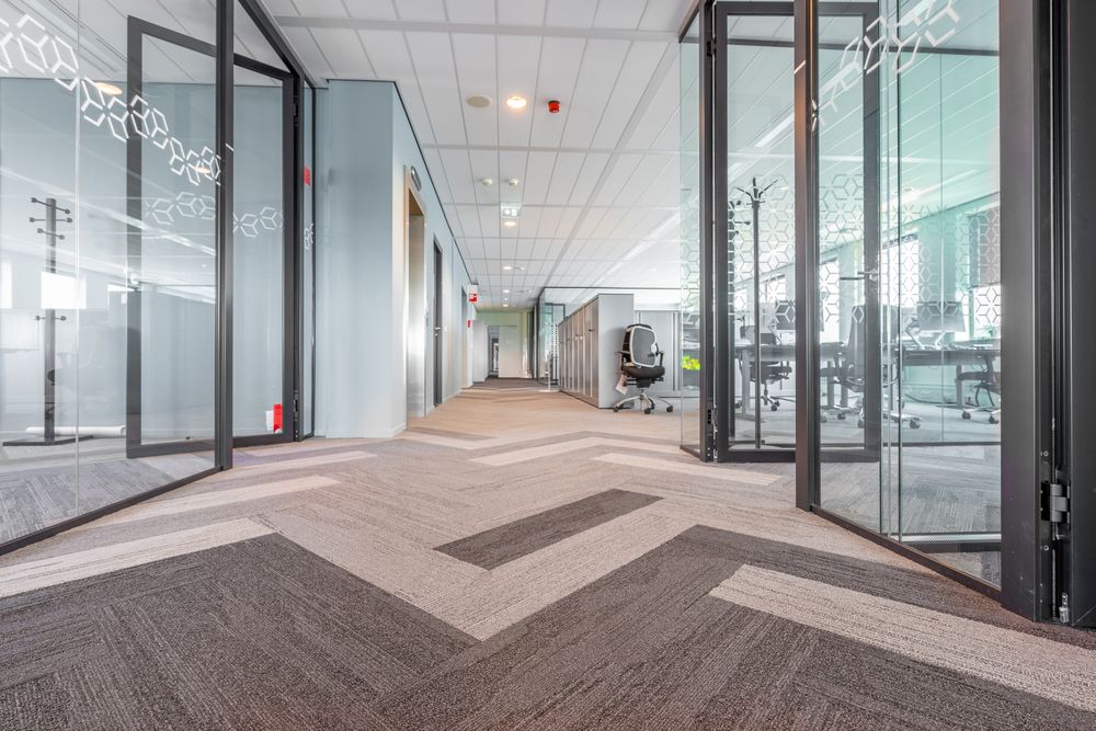 A hallway lined with glass-walled meeting rooms, the kind of sequence a candidate moves through across a multi-round interview loop