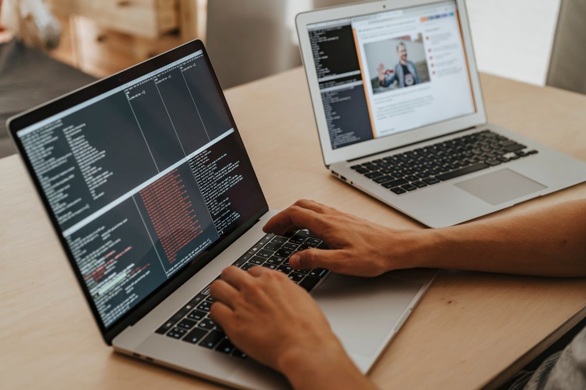 An engineer typing on a laptop showing terminal logs with red error lines, the kind of production incident story many give for tell me about a time you failed