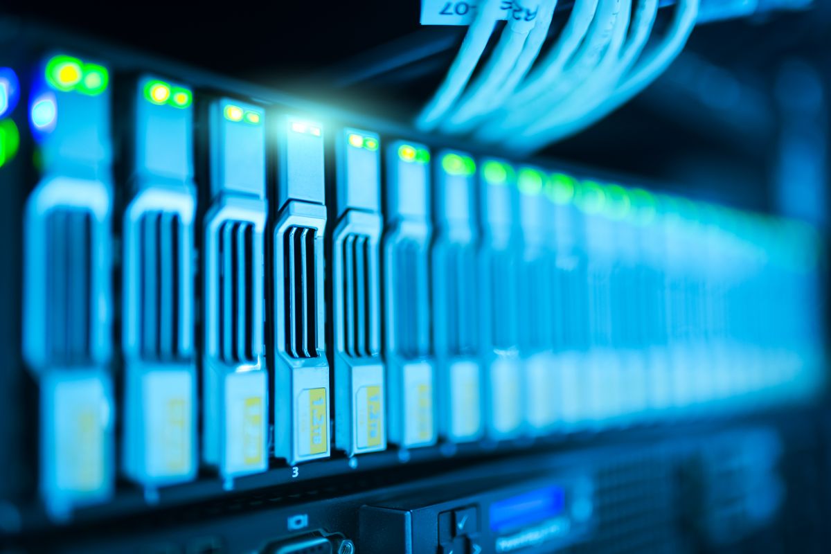 Network server rack with blinking status lights and ethernet cables, representing an async API call over the network