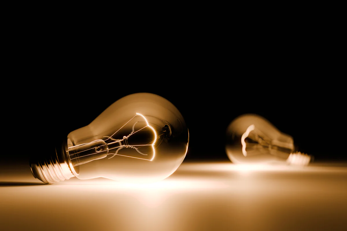 Two light bulbs on a table, one lit, for a post on taking a hint in a coding interview