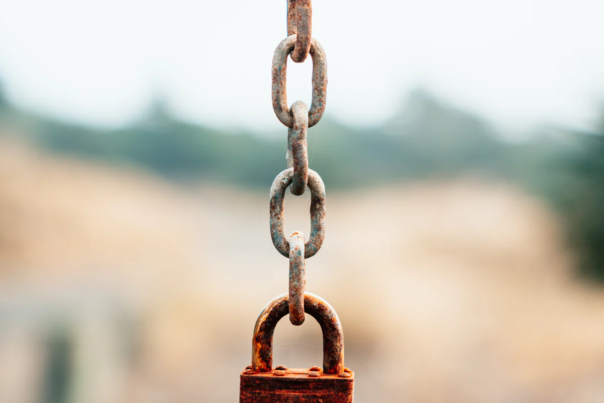 Rusty padlock hanging from a chain, illustrating a Mutex withLock deadlock in Kotlin coroutines