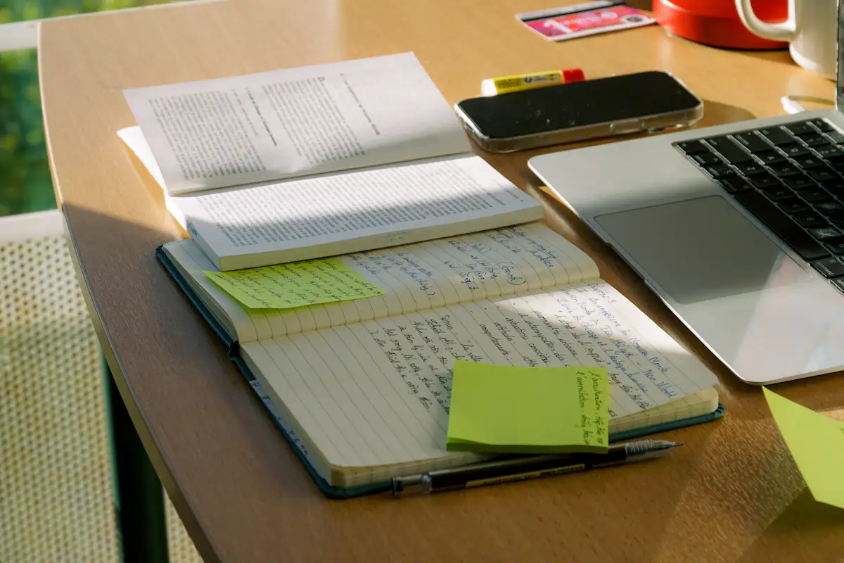Handwritten notes and sticky notes beside a laptop, prepping to answer tell me about a time you mentored someone