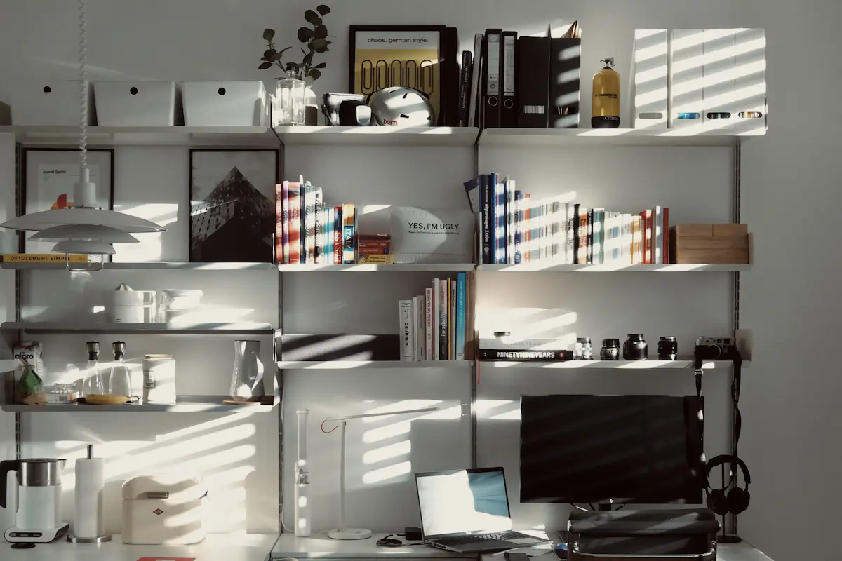 Sunlit home office desk with a laptop and bookshelves, where a candidate prepares a why do you want to work here answer