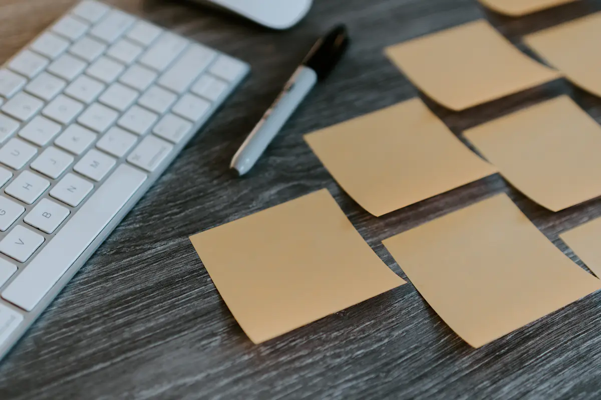 Blank sticky notes next to a keyboard, for a post on the worst manager interview question